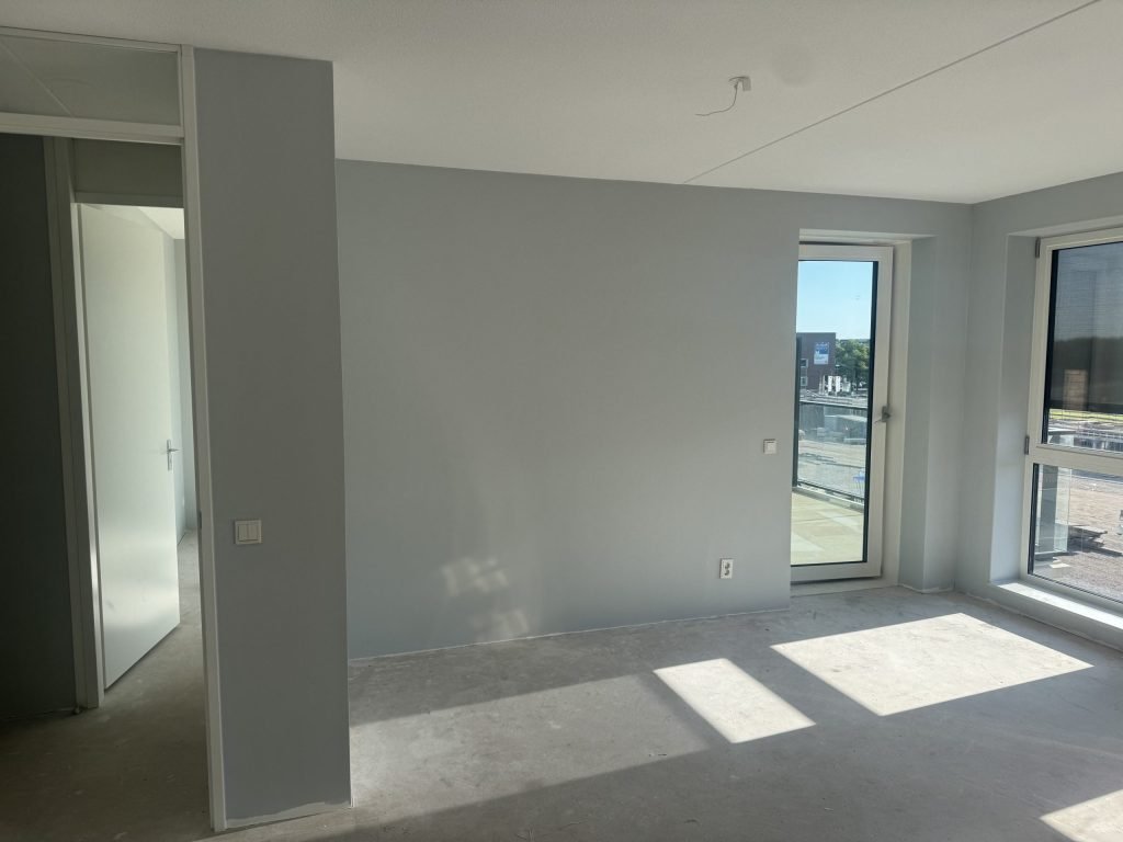 Gesausde wand in een lichte nieuwbouwkamer, zonder zichtbare naden